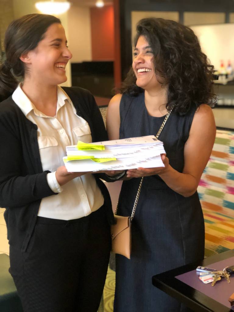 Law student Jenny Labbadia and supervising attorney Valeria Gomez, a teaching fellow with the Asylum and Human Rights Clinic at the UConn School of Law, hold an extensive evidence package that their team developed to support an immigration detainee's asylum claim.